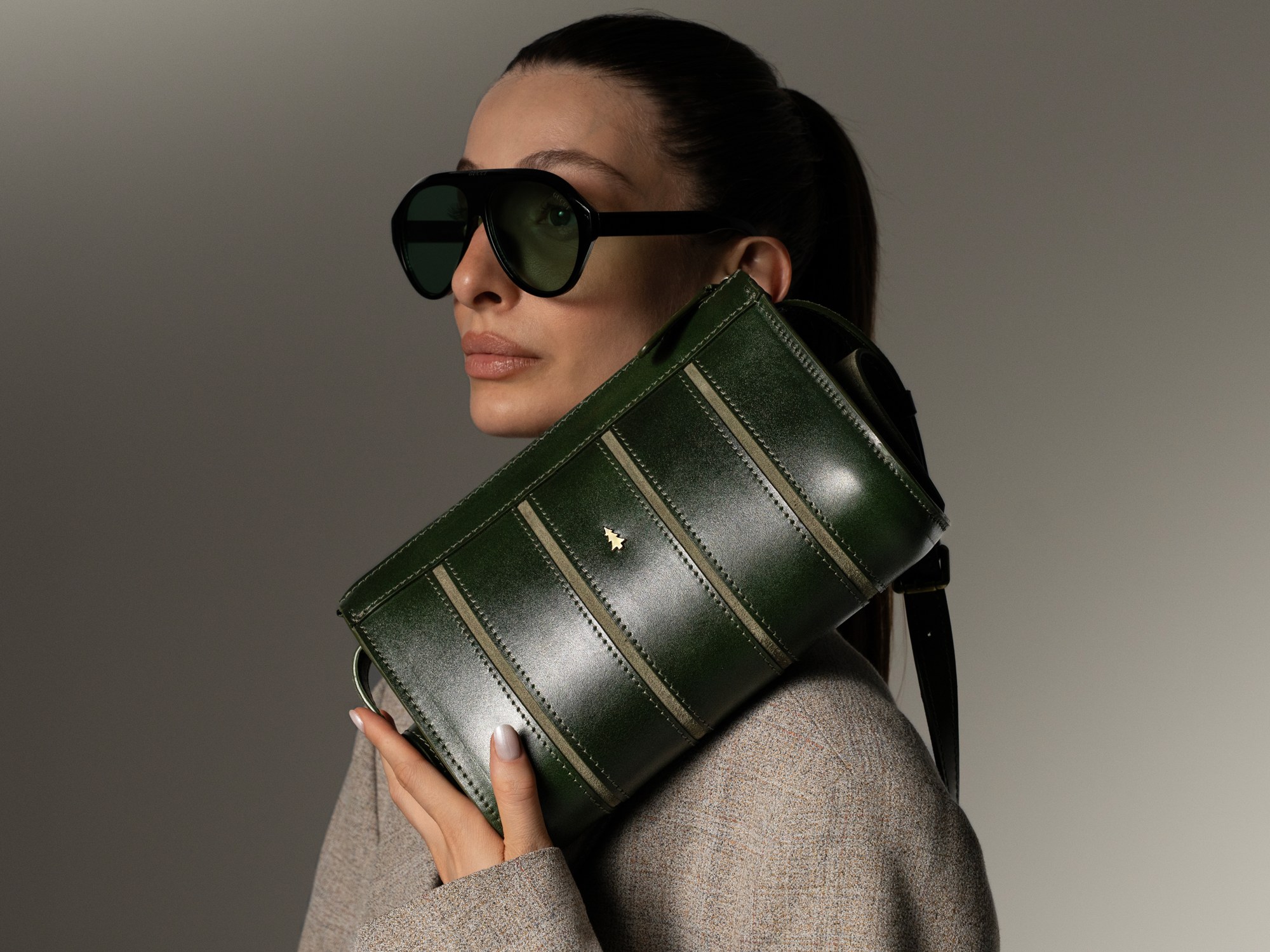 ARAS PINE Calder Clutch — forest green, worn by model — leather clutch (worn by a model), handmade in Türkiye