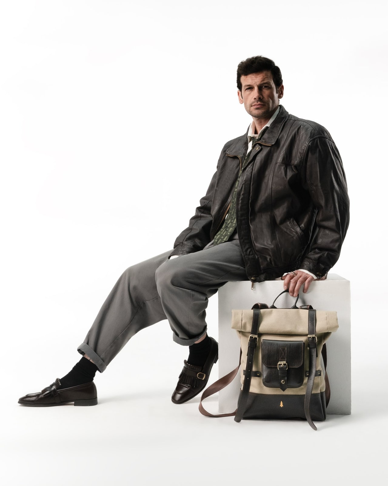 ARAS PINE Elvar Backpack — cream canvas, model seated — leather backpack (worn by a model), handmade in Türkiye
